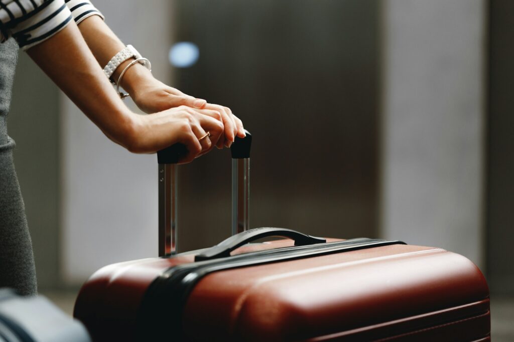 Unrecognizable businesswoman standing with travel bag close up