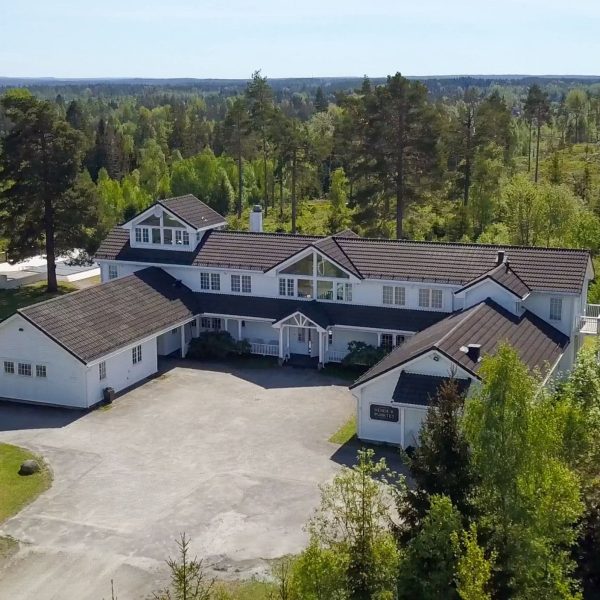 Dronefoto av forsiden av Vendepunktet. Klinikken har naturskjønne omgivelser i Vestby. Hovedbygget er staselig med ranch preg, omkranset av en flott hage og ligger uten innsyn.